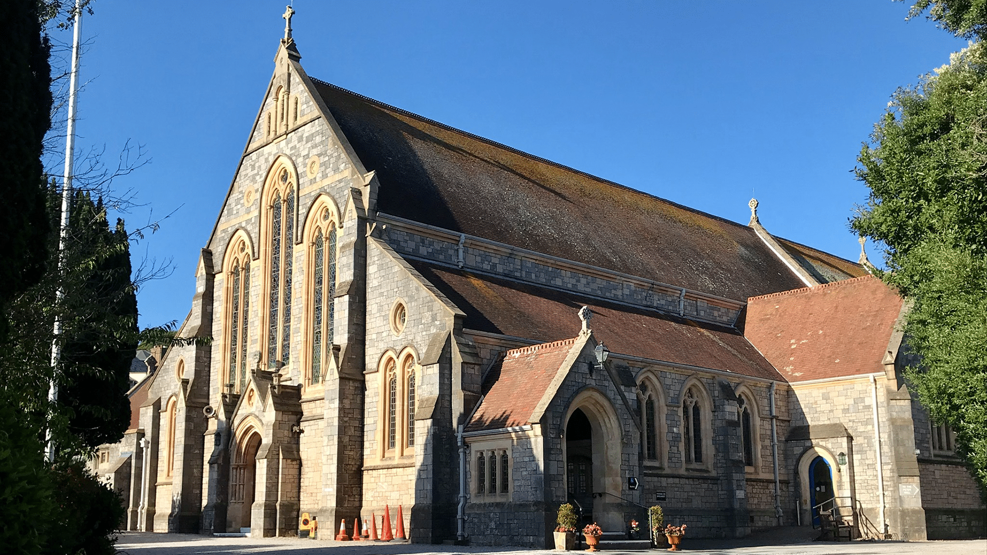 External of St Peter's Church in Budleigh. Large traditional church with high roof, limestone walls, and stained glass windows, built in 1893